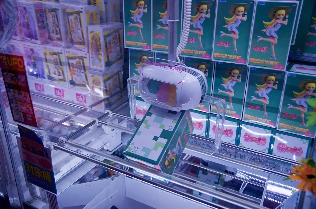 Une machine à pince SEGA UFO Catcher remplie de figurines en boîte à gagner, dans une salle d'arcade au Japon
