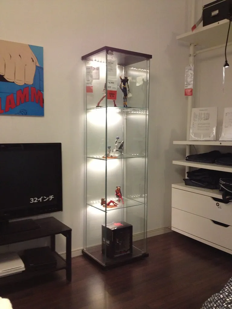 Une colonne vitrée DETOLF éclairée par des LED, garnie de figurines d'anime, dans un showroom IKEA au Japon